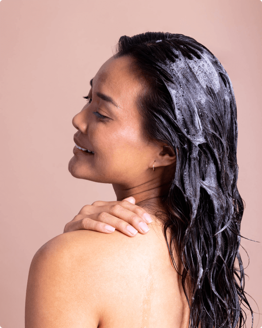 woman rubbing hair care product on her shoulder